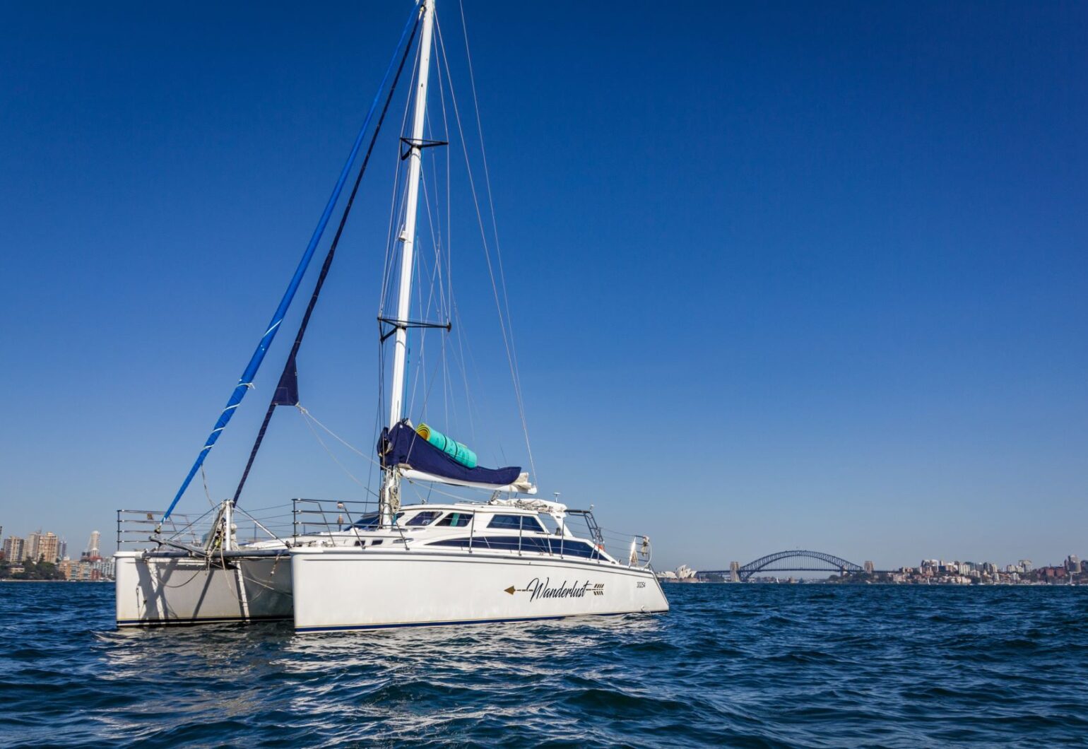 Wanderlust motor yacht side profile on the water, with sails up, from Dreamboats Wanderlust