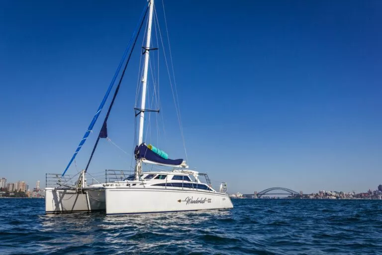 Wanderlust motor yacht side profile on the water, with sails up, from Dreamboats Wanderlust
