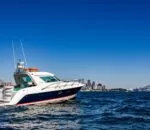 Inception sports cruiser navigating through clear blue waters with skyline backdrop.