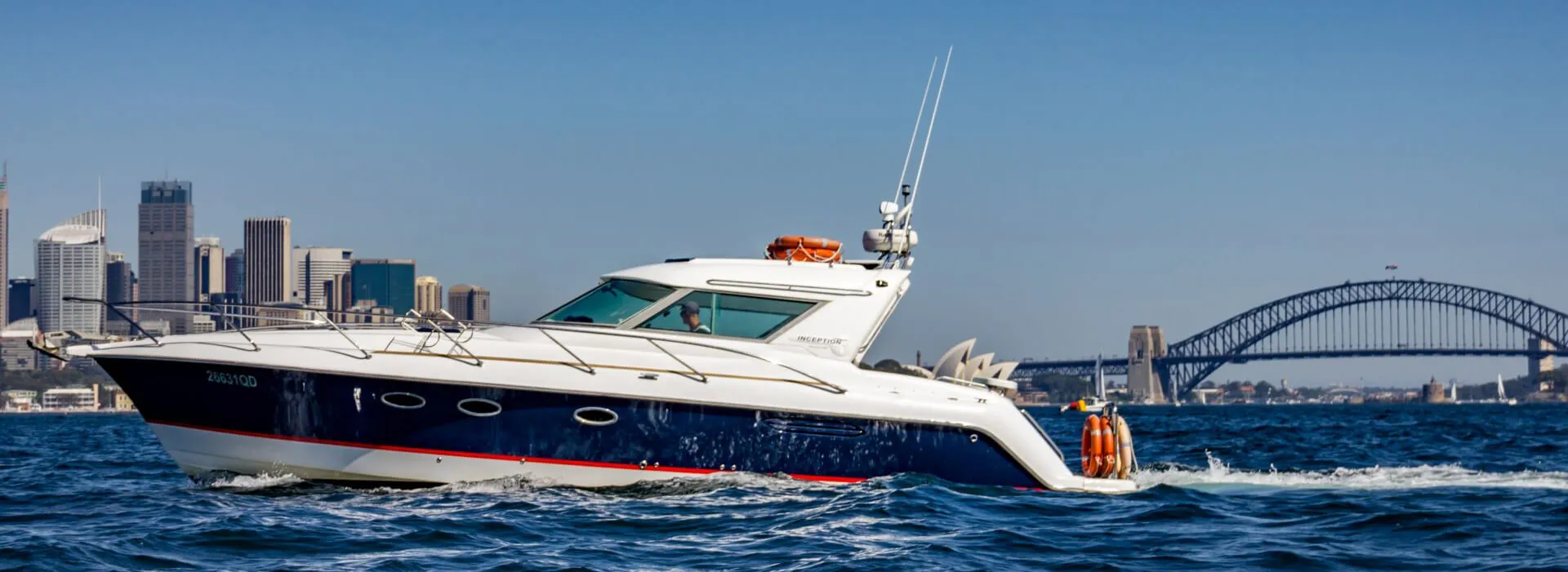 Inception sports cruiser navigating waters with city skyline and bridge backdrop. Sleek Inception sports cruiser cruising through water with urban skyline behind.