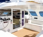 Bright interior of a boat with a steering wheel and seating area. wanderlust boat sydney