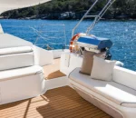 Luxurious boat interior with white seating and a view of blue water. Different variation #1: Elegant boat deck featuring white cushions and scenic ocean backdrop.