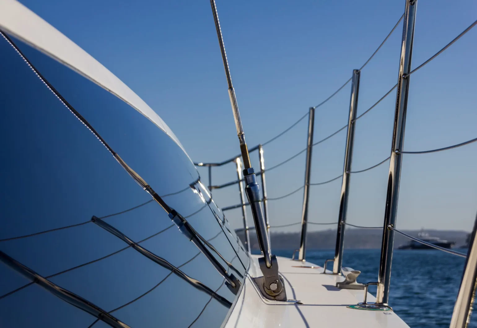 Polished safety railings and reflective windows on the side deck of the Wanderlust motoryacht by Dreamboats.