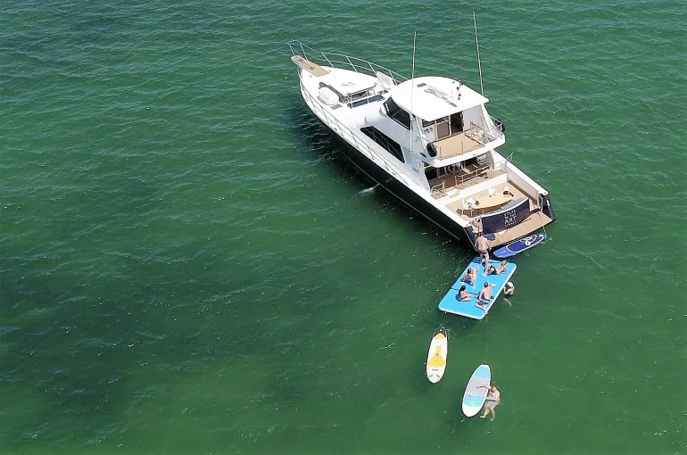State of the Art yacht anchored in Sydney Harbour, taken from above with water toys alongside