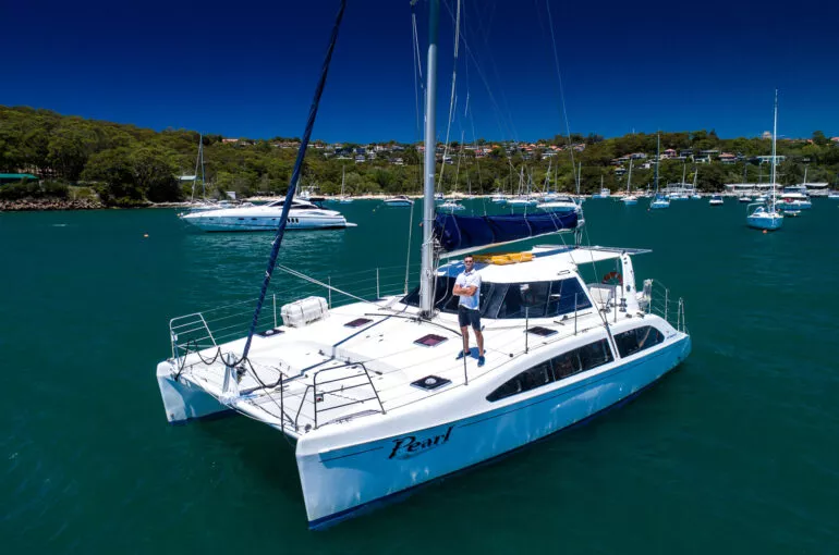 Sailing Pearl Catamaran anchored in calm waters with a clear blue sky.