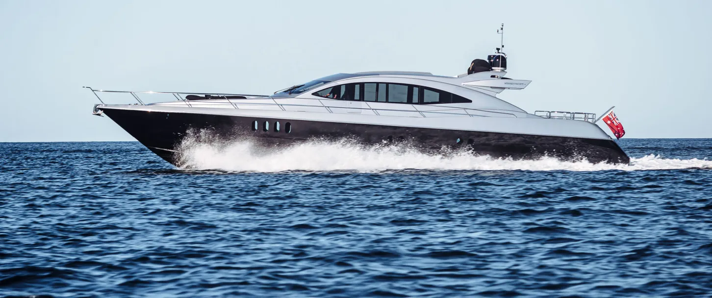 Sleek motorboat cruising through calm waters with a clear sky. Fast luxury boat gliding over waves under a bright blue sky.