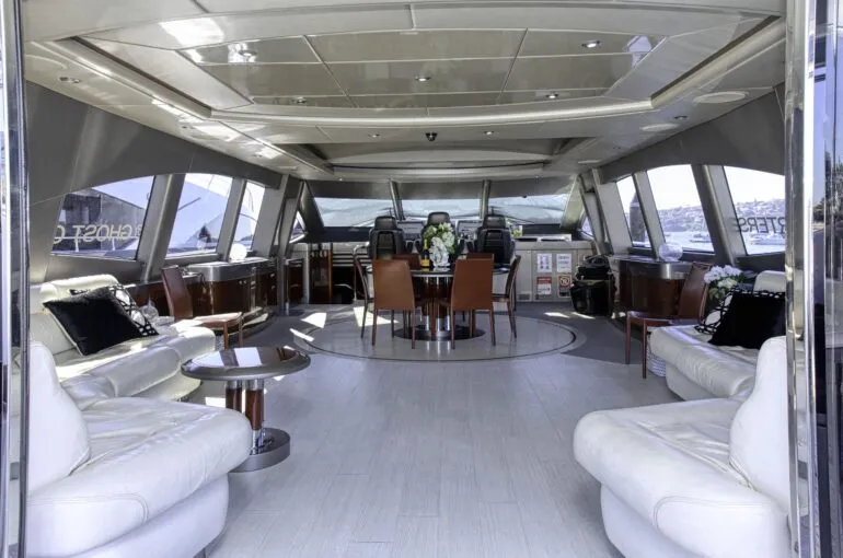 Spacious interior of a luxury boat with seating and dining area. Elegant boat interior featuring comfortable seating and a dining table.