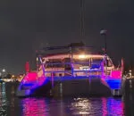Colorful lights illuminate the spellbound boat at night on the water.