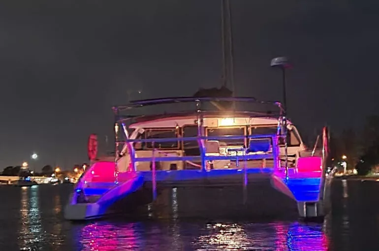 Colorful lights illuminate the spellbound boat at night on the water.