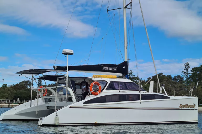 Sleek spellbound boat docked on calm waters under a blue sky.