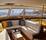 Cozy interior of the Spellbound boat with bright cushions and scenic views.