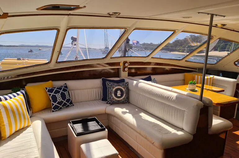 Cozy interior of the Spellbound boat with bright cushions and scenic views.