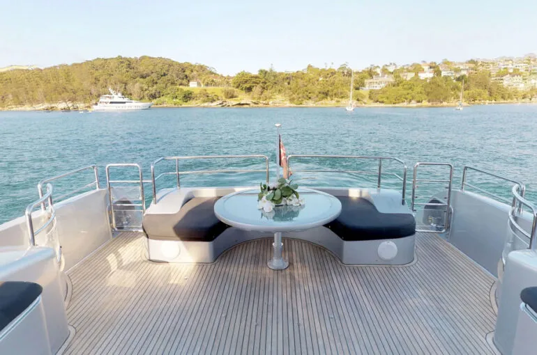 Spacious outdoor seating area on a boat overlooking calm waters. Variation #1: Comfortable seating arrangement on a boat with scenic water views.