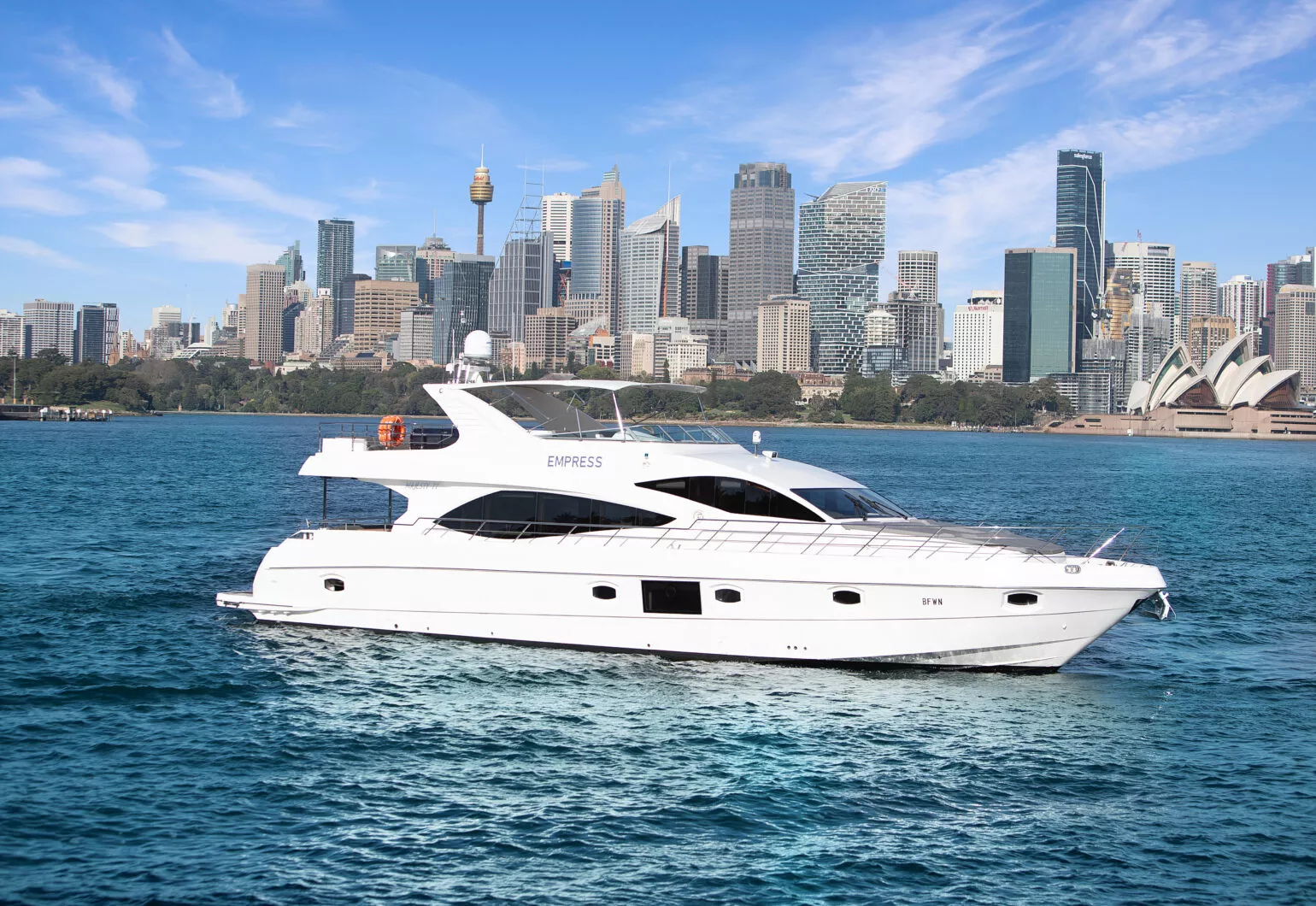 Luxury yacht cruising in front of a city skyline and water. Elegant boat sailing near urban skyline and waterway.