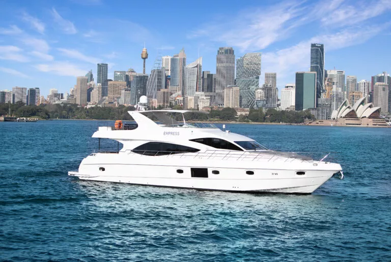 Luxury yacht cruising in front of a city skyline and water. Elegant boat sailing near urban skyline and waterway.