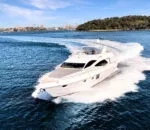 Luxurious Empress Motoryacht cruising through the blue waters with city skyline. Elegant Empress Motoryacht navigating waves near a scenic coastline.