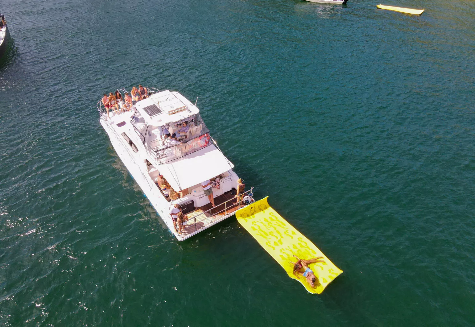 Life’s Good catamaran anchored with guests enjoying water activities nearby.