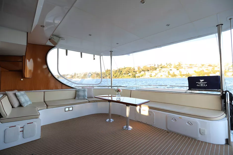 Spacious interior lounge area on a Passion Catamaran with scenic views. Variation #1: Elegant seating arrangement inside a Passion Catamaran with water views.