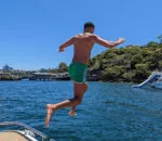 A person jumps off a Passion Catamaran into the water.