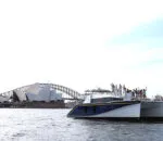 Passion Catamaran docked near a modern architectural landmark.