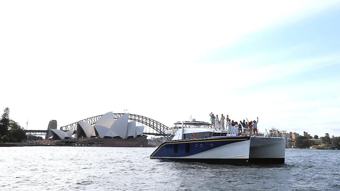 Passion Catamaran docked near a modern architectural landmark.