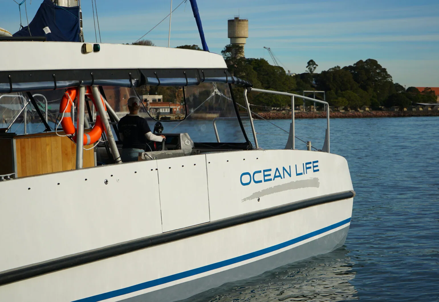 Catamaran cruising on calm waters near Sydney's coastline.