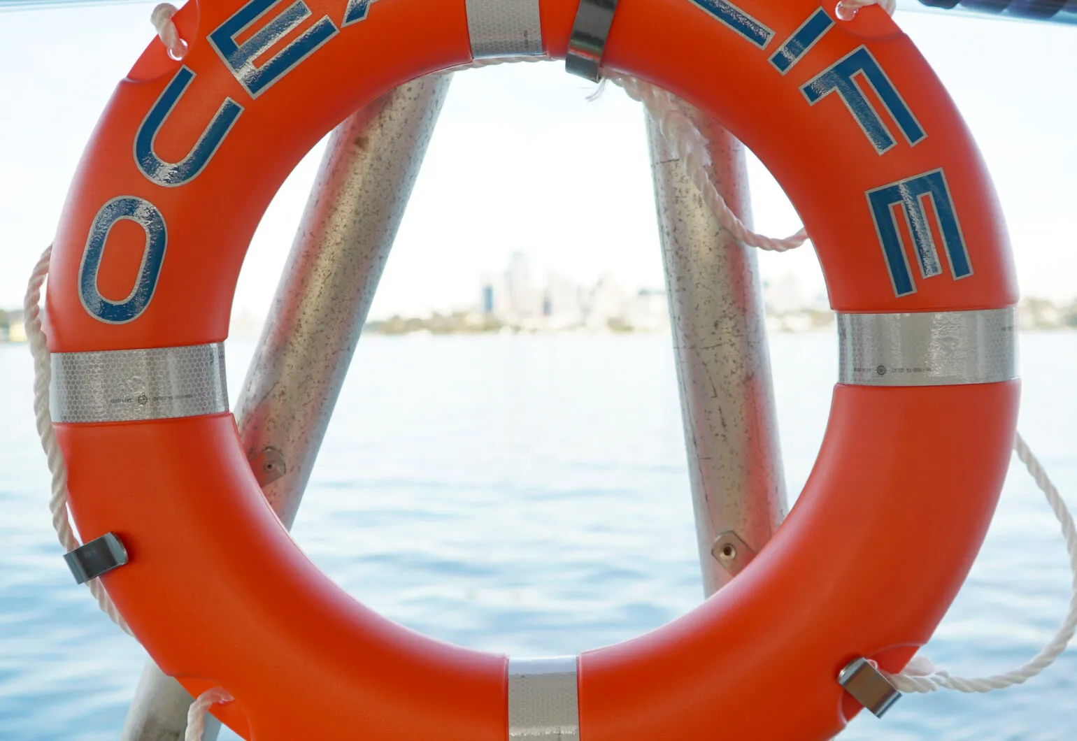 Bright orange lifebuoy labeled "OCEAN LIFE" against a water background.
