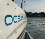 Catamaran named Ocean Life gliding through calm waters in Sydney.